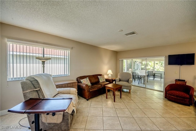 living room with light tile patterned flooring and a textured ceiling