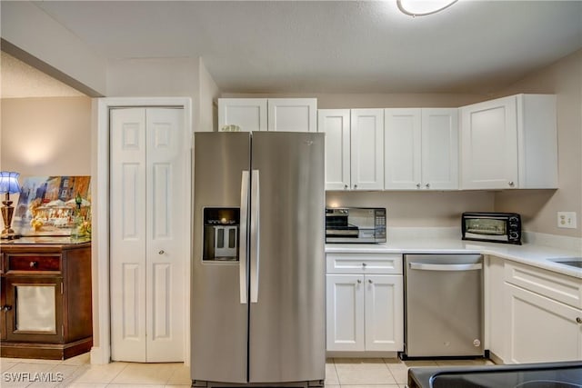 kitchen with white cabinetry, light tile patterned flooring, and appliances with stainless steel finishes