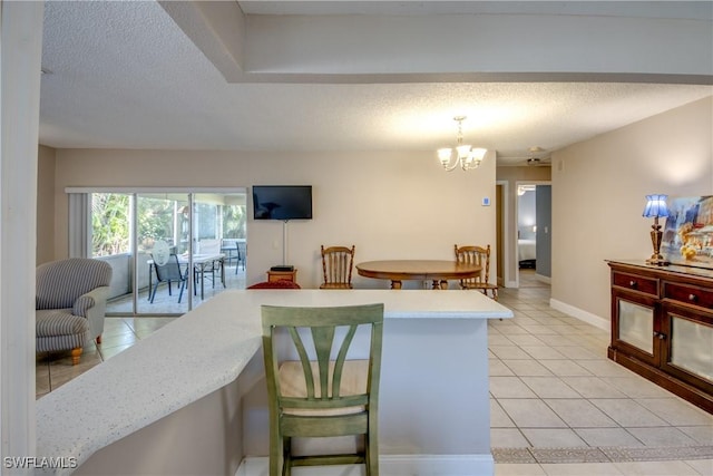 kitchen featuring light tile patterned flooring, pendant lighting, a chandelier, and a textured ceiling