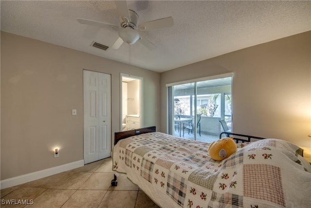 bedroom with ensuite bath, a textured ceiling, light tile patterned floors, access to outside, and ceiling fan