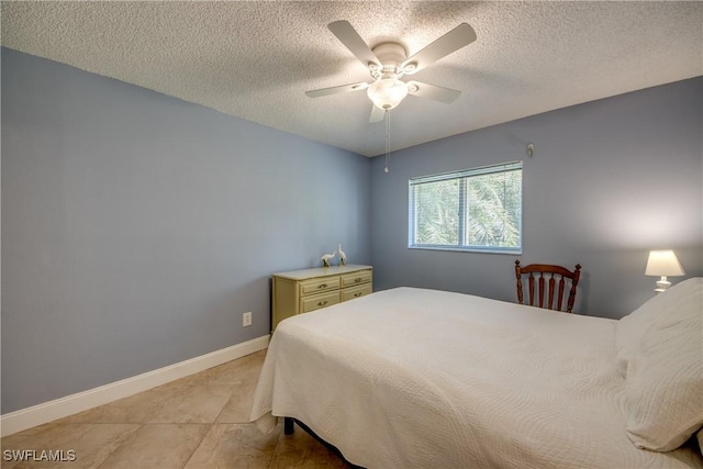 bedroom with ceiling fan and a textured ceiling