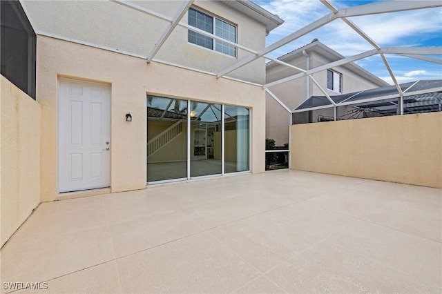 view of patio featuring a lanai