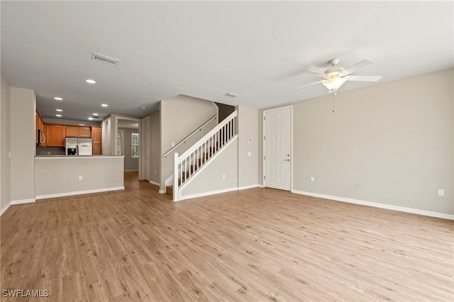 unfurnished living room featuring ceiling fan and light wood-type flooring