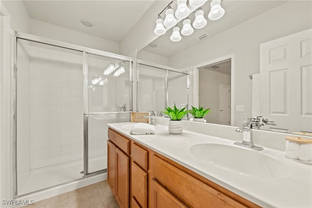 bathroom with an enclosed shower, vanity, and tile patterned flooring