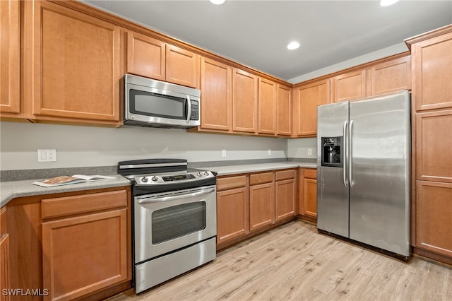 kitchen featuring appliances with stainless steel finishes and light hardwood / wood-style floors