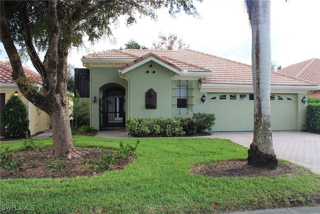 mediterranean / spanish-style home featuring a front lawn and a garage