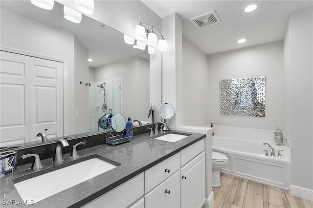 full bathroom with vanity, separate shower and tub, hardwood / wood-style flooring, and toilet