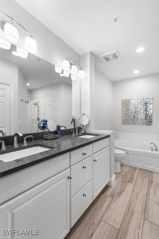 full bathroom featuring vanity, toilet, separate shower and tub, and hardwood / wood-style floors