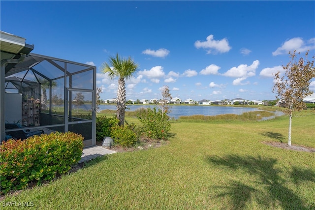 view of yard featuring a water view and glass enclosure