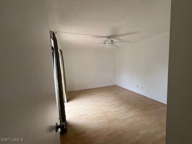 spare room with a textured ceiling, light hardwood / wood-style floors, and ceiling fan