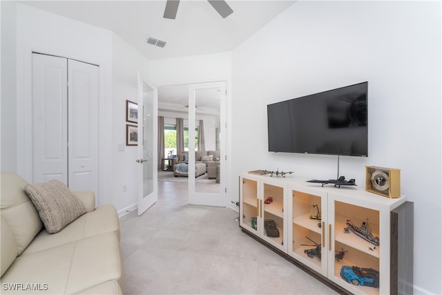 living room featuring french doors and ceiling fan