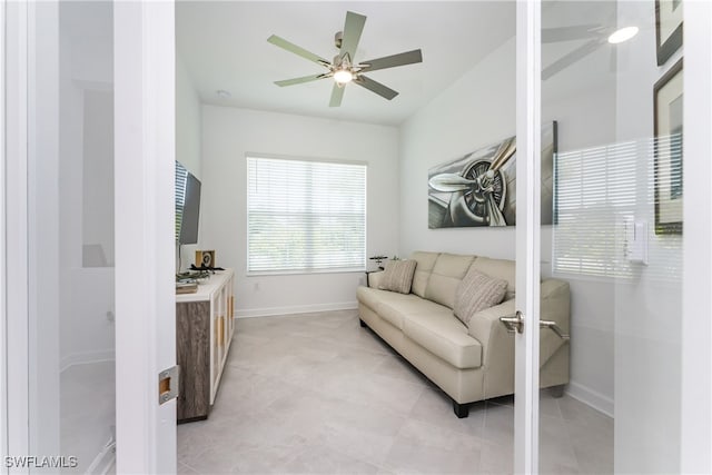 living area featuring ceiling fan and light tile patterned floors