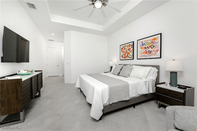 tiled bedroom with a tray ceiling and ceiling fan