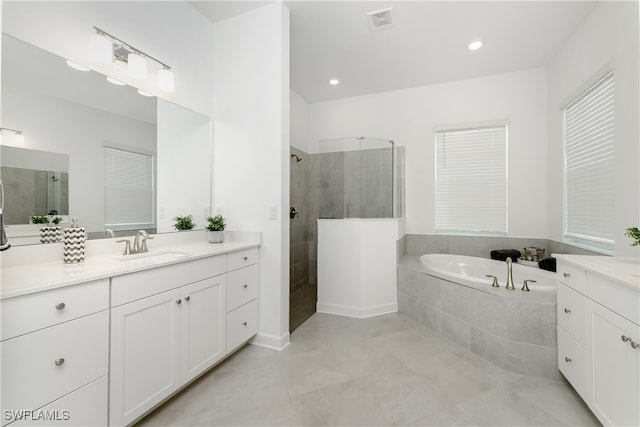 bathroom featuring independent shower and bath, tile patterned flooring, and vanity