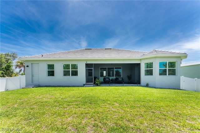 rear view of house featuring a lawn