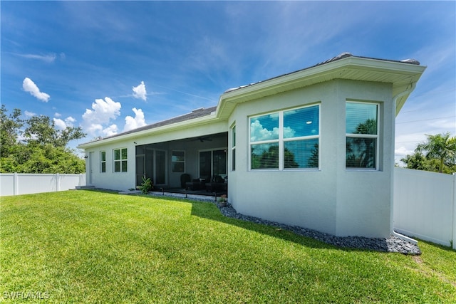 back of house featuring a sunroom and a yard