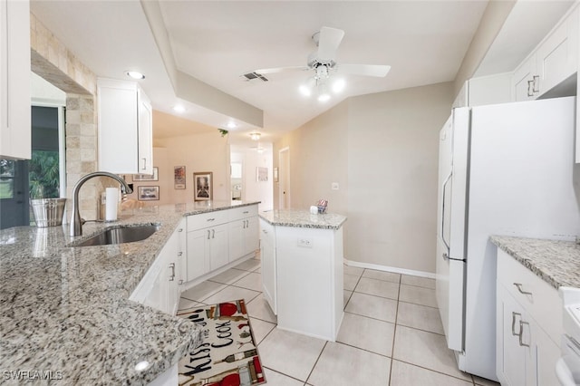 kitchen featuring light stone countertops, sink, a center island, white cabinetry, and white refrigerator