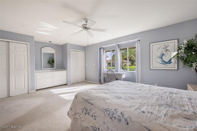 carpeted bedroom with two closets and ceiling fan