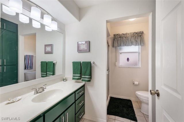 bathroom featuring toilet, vanity, and tile patterned flooring