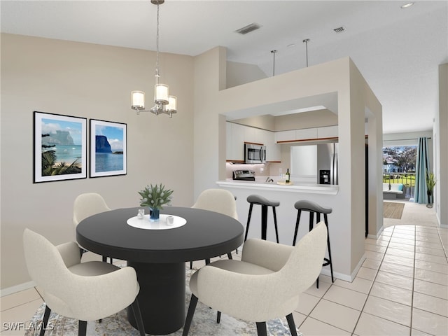 dining area featuring light tile patterned floors, a chandelier, and high vaulted ceiling