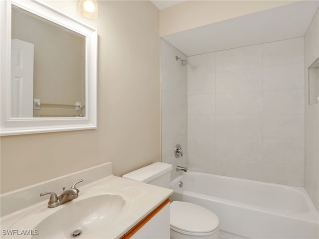 full bathroom with tiled shower / bath, vanity, and toilet