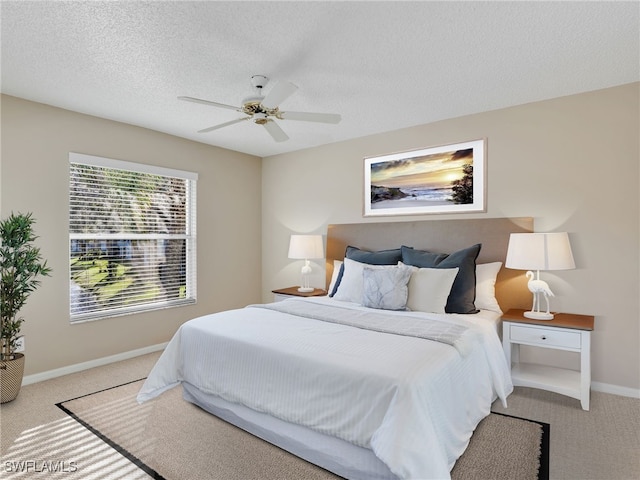 bedroom with ceiling fan, light carpet, and a textured ceiling