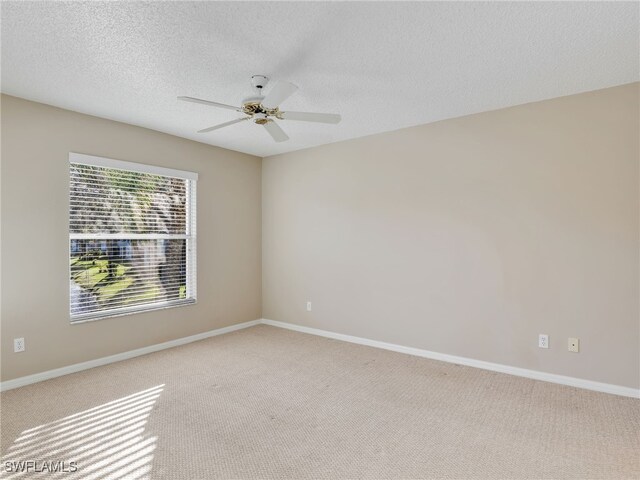 carpeted spare room with ceiling fan and a textured ceiling