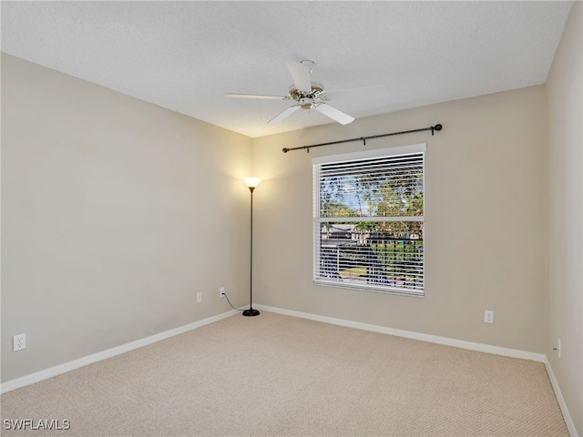 unfurnished room with carpet flooring, ceiling fan, and a textured ceiling