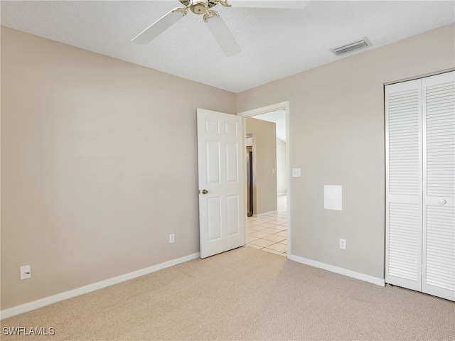 unfurnished bedroom with ceiling fan, a closet, and light colored carpet