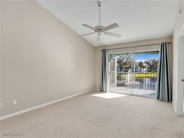 spare room featuring ceiling fan, a textured ceiling, lofted ceiling, light carpet, and a water view