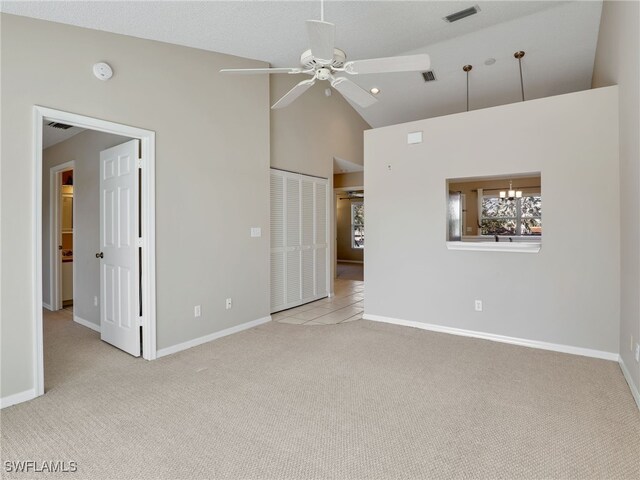 interior space featuring high vaulted ceiling and ceiling fan with notable chandelier