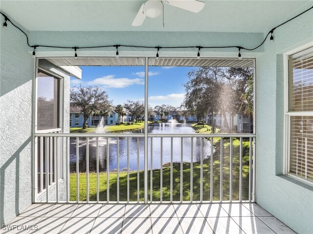 unfurnished sunroom with a water view, ceiling fan, and a healthy amount of sunlight