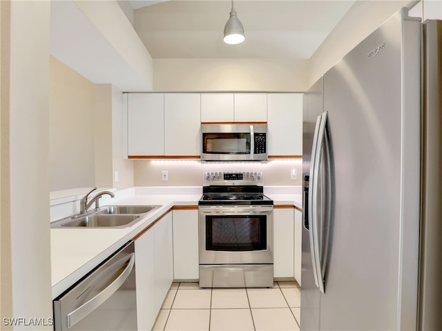 kitchen with hanging light fixtures, sink, white cabinets, and stainless steel appliances