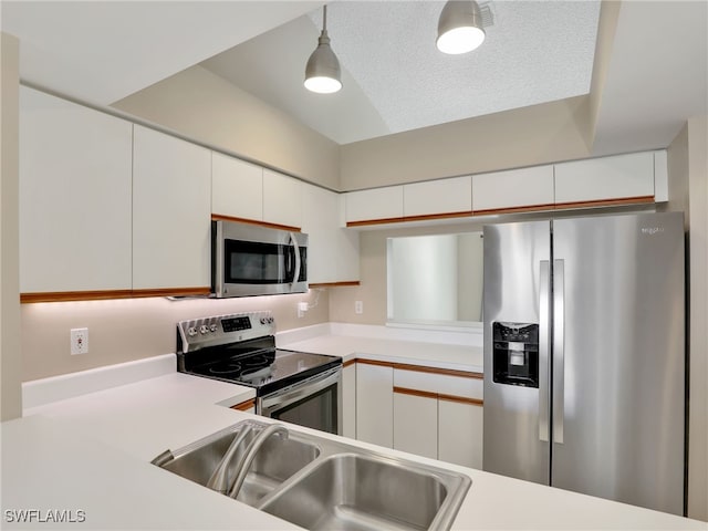 kitchen featuring sink, white cabinets, hanging light fixtures, and appliances with stainless steel finishes