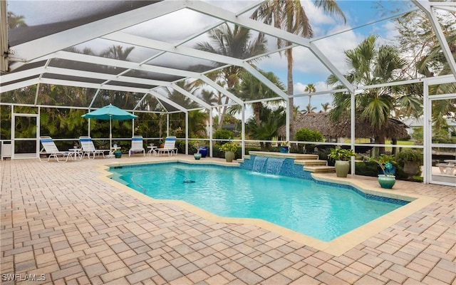 view of swimming pool with pool water feature, a patio area, and a lanai