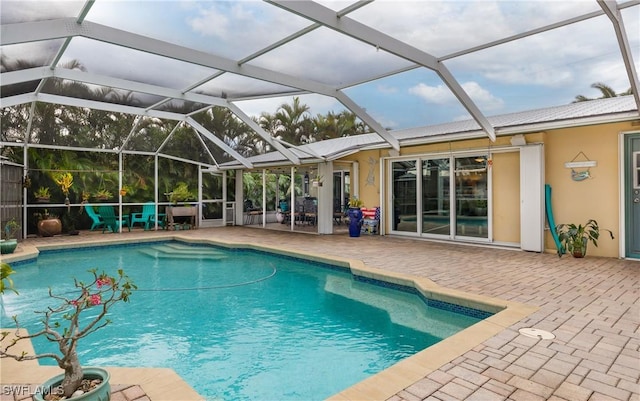 view of swimming pool with glass enclosure and a patio area