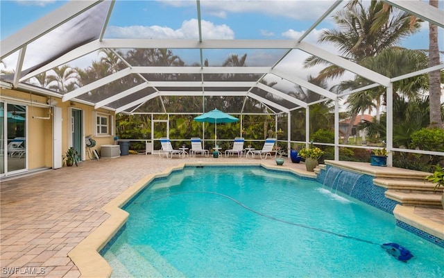 view of swimming pool featuring pool water feature, glass enclosure, and a patio area