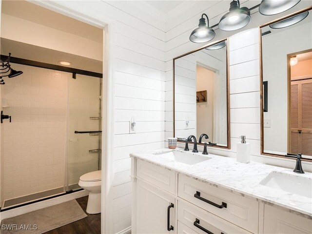 bathroom with vanity, hardwood / wood-style floors, a tile shower, and toilet