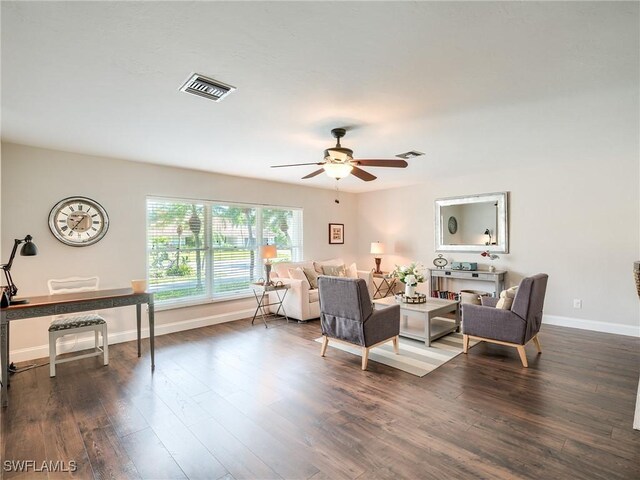 living room featuring dark wood-type flooring and ceiling fan