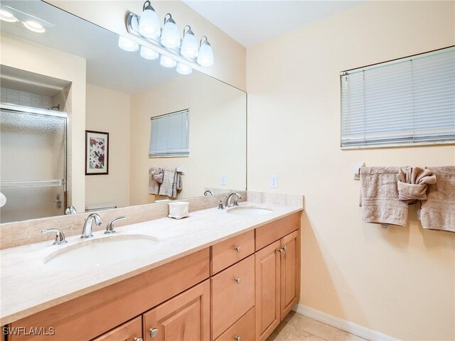 bathroom with vanity, a shower with shower door, and tile patterned floors