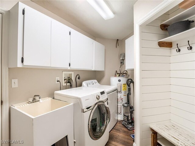 laundry room featuring sink, washer and dryer, dark hardwood / wood-style flooring, and water heater