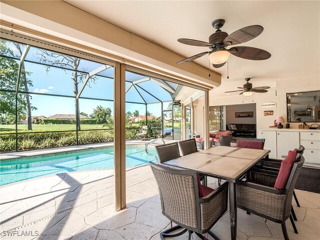 view of swimming pool with a patio, ceiling fan, and a lanai