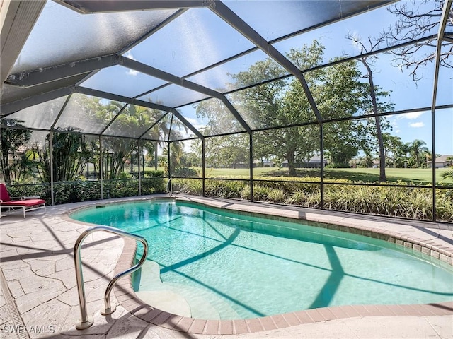 view of pool with a patio area and glass enclosure