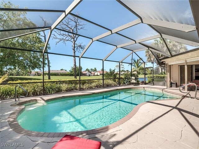 view of pool with a patio area and glass enclosure