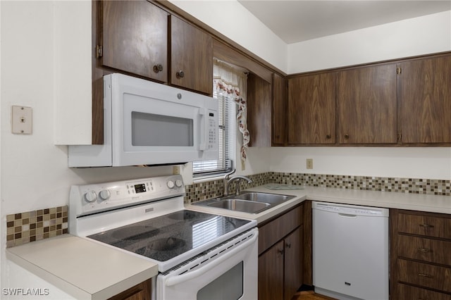 kitchen with backsplash, sink, dark brown cabinetry, and white appliances