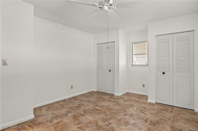 unfurnished bedroom with two closets and ceiling fan