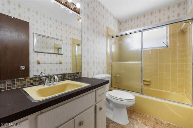 full bathroom featuring vanity, combined bath / shower with glass door, toilet, and tasteful backsplash