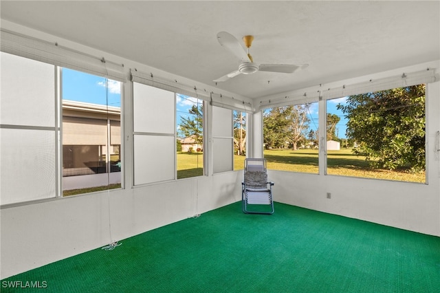 unfurnished sunroom featuring ceiling fan and plenty of natural light