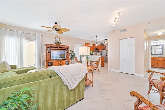 tiled living room with ceiling fan and plenty of natural light