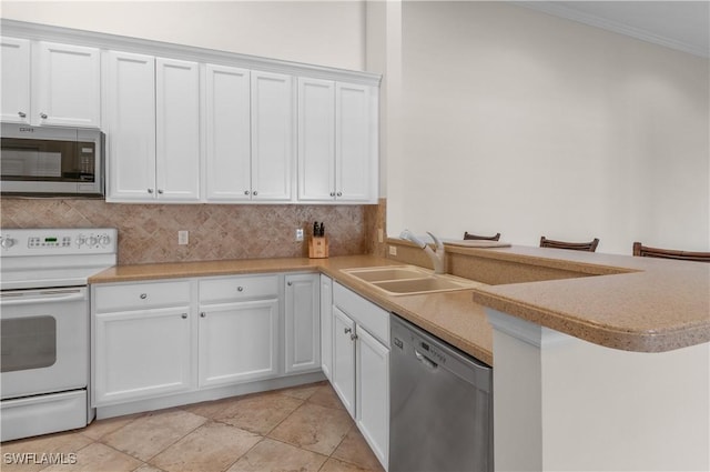 kitchen with stainless steel appliances, a sink, decorative backsplash, white cabinetry, and light countertops